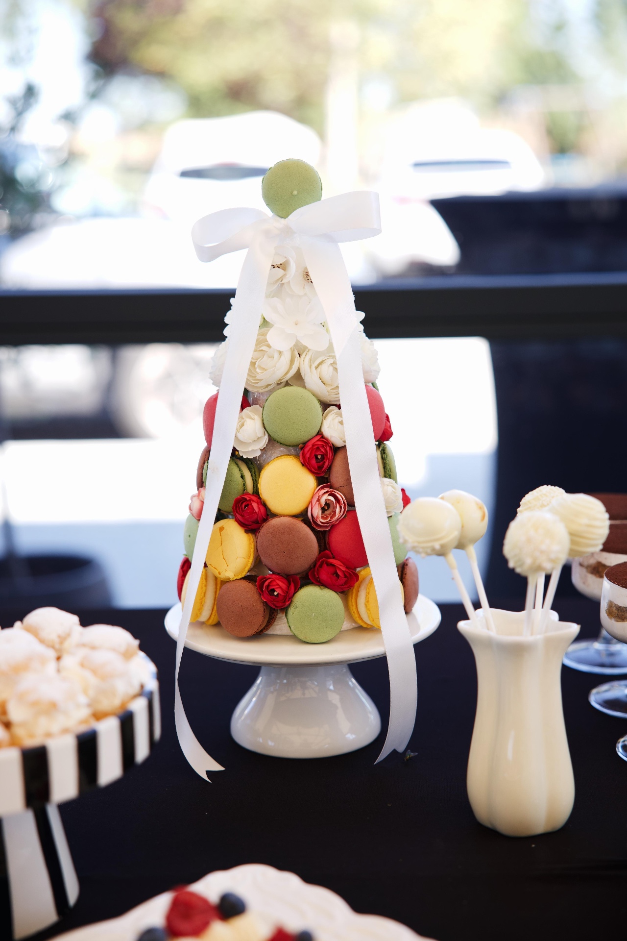 Toranj od šarenih macaronsa s bijelom mašnom